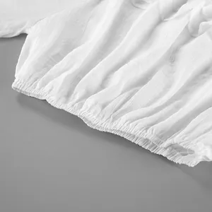Vue macro détaillée de la taille élastiquée et du tissu texturé d'une chemise blanche chic