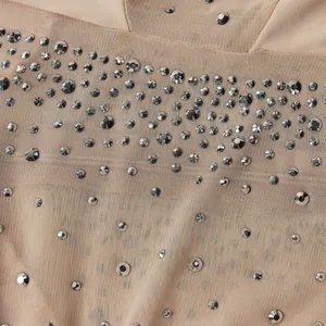 Dettaglio ravvicinato del tessuto a rete velato con decorazioni in strass per body