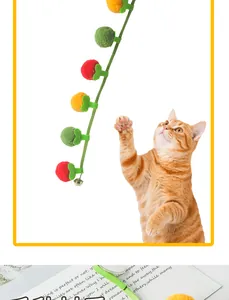 Detailed close-up of colorful pom-pom cat teaser toy featuring a small metal bell
