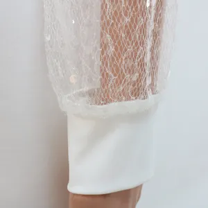 Detalle de cerca de la manga de malla con lentejuelas blancas y puño elástico sólido