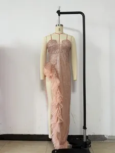 Detailansicht eines roségoldenen Pailletten-Abendkleids mit Tüllrüschen und Schlitz