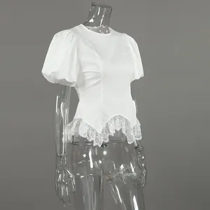 Gedetailleerd zijaanzicht van witte blouse met pofmouwen en elegante kanten zoom op pop