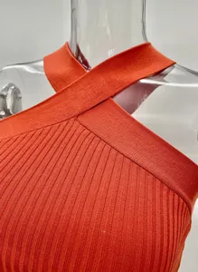Detail shot of orange ribbed halter neck knitted tank top with criss-cross straps