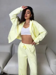 Fashionable pale yellow tracksuit set with zip-up hoodie and matching pants on model
