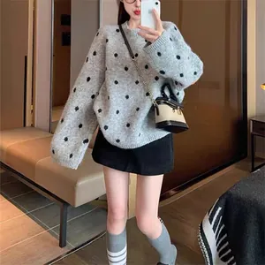 Vista completa di un maglione grigio a pois con girocollo su una modella