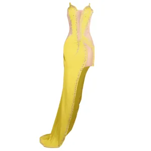 Detailed view of yellow evening dress featuring rhinestone accents and mesh panels.