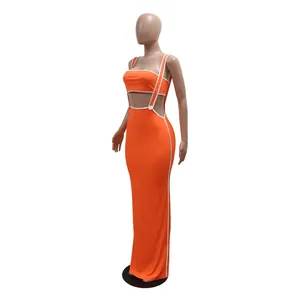 Side detail of vibrant orange ribbed two-piece suspender maxi dress with white piping