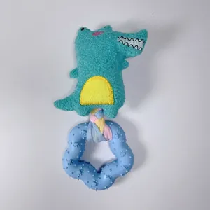 Dettaglio di un giocattolo sonoro a coccodrillo in peluche con anello da masticare