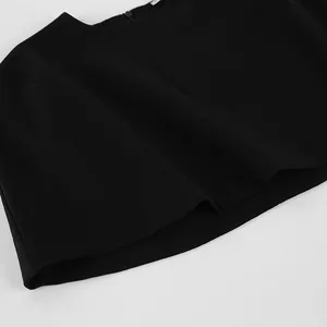 Vue détaillée d'un haut cape noir élégant de style français avec une texture de tissu lisse.