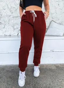Close-up of burgundy high-waisted drawstring joggers on a model in a casual setting