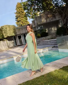 Robe longue élégante en mousseline vert sauge avec détail d'écharpe au bord de la piscine.