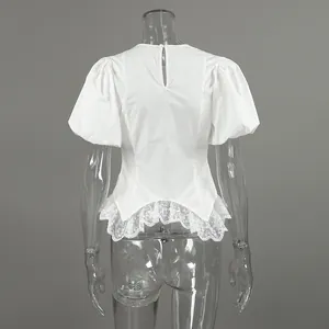 Gedetailleerd achteraanzicht van een witte blouse met pofmouwen en een kanten ruffelzoom