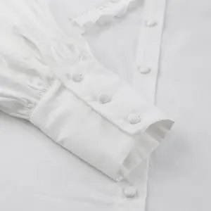 Detailed macro shot of white cotton blouse sleeve cuff with vintage covered buttons