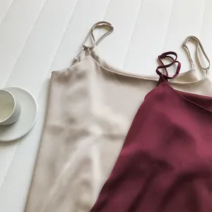 Primo piano di canotte in raso setoso con spalline sottili regolabili in beige e bordeaux