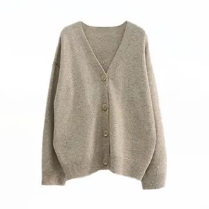 Detail of oversized beige V-neck knitted cardigan with buttons and ribbed hem