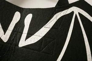 Macro detail shot showing the black felt texture and white pattern of pet bat wings