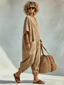 Full view of women's loose tan linen-look jumpsuit with deep V-neck and large side pockets
