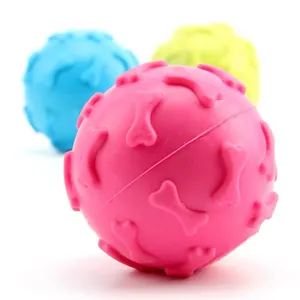 Close-up of colorful TPR squeaky dog toy balls featuring embossed bone patterns for teeth cleaning