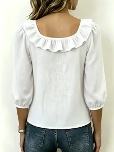 Gedetailleerd achteraanzicht van een witte blouse met rucheskraag en stijlvolle pofmouwen