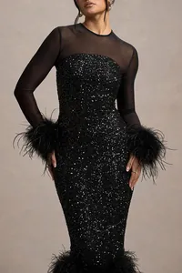 Close-up of elegant black sequin party dress with sheer mesh sleeves and feather cuffs.