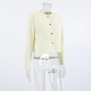 Detailansicht einer eleganten cremefarbenen Tweedjacke mit Goldknöpfen an einer Schaufensterpuppe