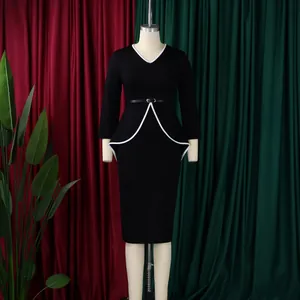 Elegant black long-sleeved dress with white trim and peplum detail shown on a mannequin.