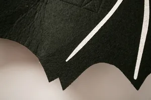 Detailed macro view of black felt pet bat wing costume with white bone pattern for Halloween