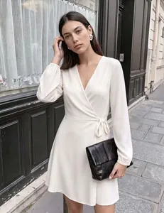 Elegante vestido cruzado blanco con cuello en V, mangas abullonadas y lazo.