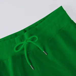 Detailed macro shot showcasing the waistband and drawstring of green wide-leg pants