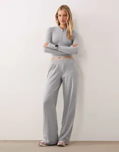 Modella che indossa felpa grigia con cappuccio e zip e pantaloni larghi abbinati