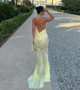 Back detail of a sexy pale yellow sequined mermaid evening gown with an open cowl back