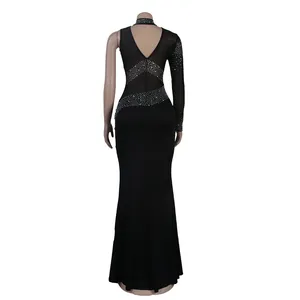 Vista trasera de vestido de noche negro con paneles de malla y detalles de pedrería