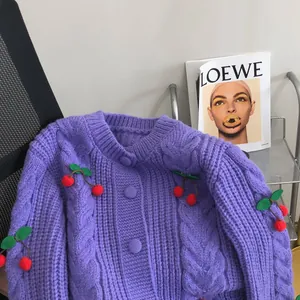 Detail of purple chunky knit cardigan with cute cherry decorations and cable pattern