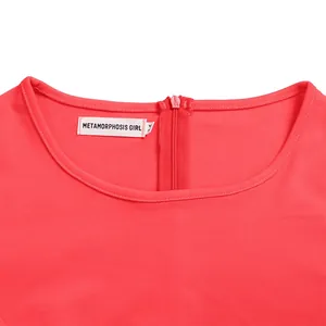 Close-up of pink dress neckline showing zipper and Metamorphosis Girl brand tag