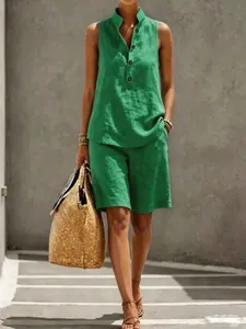 Green sleeveless linen two-piece set with buttoned stand collar and matching shorts.