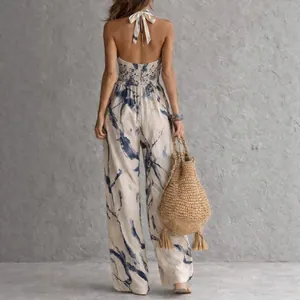 Back view of a bohemian halter neck sleeveless jumpsuit featuring blue marble tie-dye print