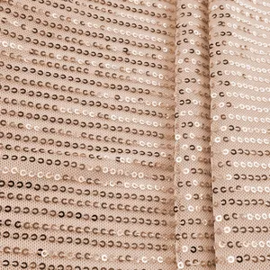 Macro detail showing rose gold sequin fabric on mesh backing for a women's stylish tank top