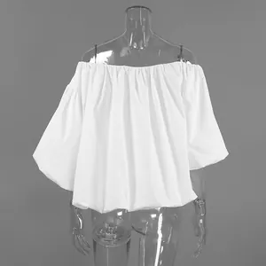 Detailed view of white off-shoulder puff sleeve cotton blouse on a clear mannequin