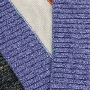 Detalle de primer plano de un cárdigan de punto a rayas con texturas azules y blancas.
