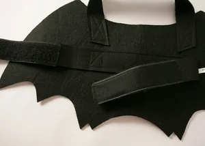 Close-up detail of black felt bat wings pet costume featuring adjustable velcro straps