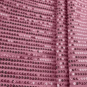 Close-up of sparkling sequin texture on the mauve pink fabric of the sleeveless tank top