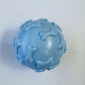 Close-up view of a light blue TPR rubber squeaky dog toy ball with raised bone patterns