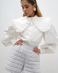 Chic white cotton blouse with oversized ruffled doll collar and puff sleeves.