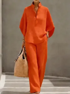 Vue d'ensemble de l'ensemble haut boutonné orange vif et pantalon large.