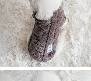 Detailed macro view of grey plush dog vest with leash D-ring on white rug