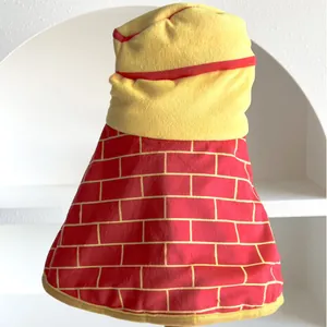 Vue détaillée d'une cape de Noël pour animaux avec motif de briques jaunes et col en peluche.