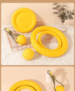 Detailed view of bright yellow durable dog toys including ring, ball and frisbee on white rug