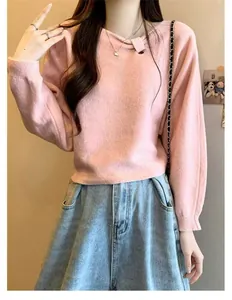 Detail view of pink knit sweater featuring an asymmetrical pleated collar design.
