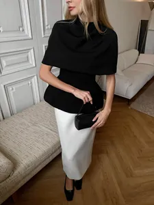 Haut cape noir élégant de style français et jupe longue blanche dans un intérieur lumineux