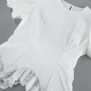 Detailweergave van witte blouse met pofmouwen en verfijnde kanten zoomafwerking